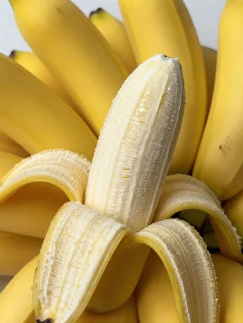 Värske banaan tervena ja viilutatult, kausis ja maalähedasel laual