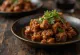 Beef Rendang serveerituna riisi ja värske koriandriga